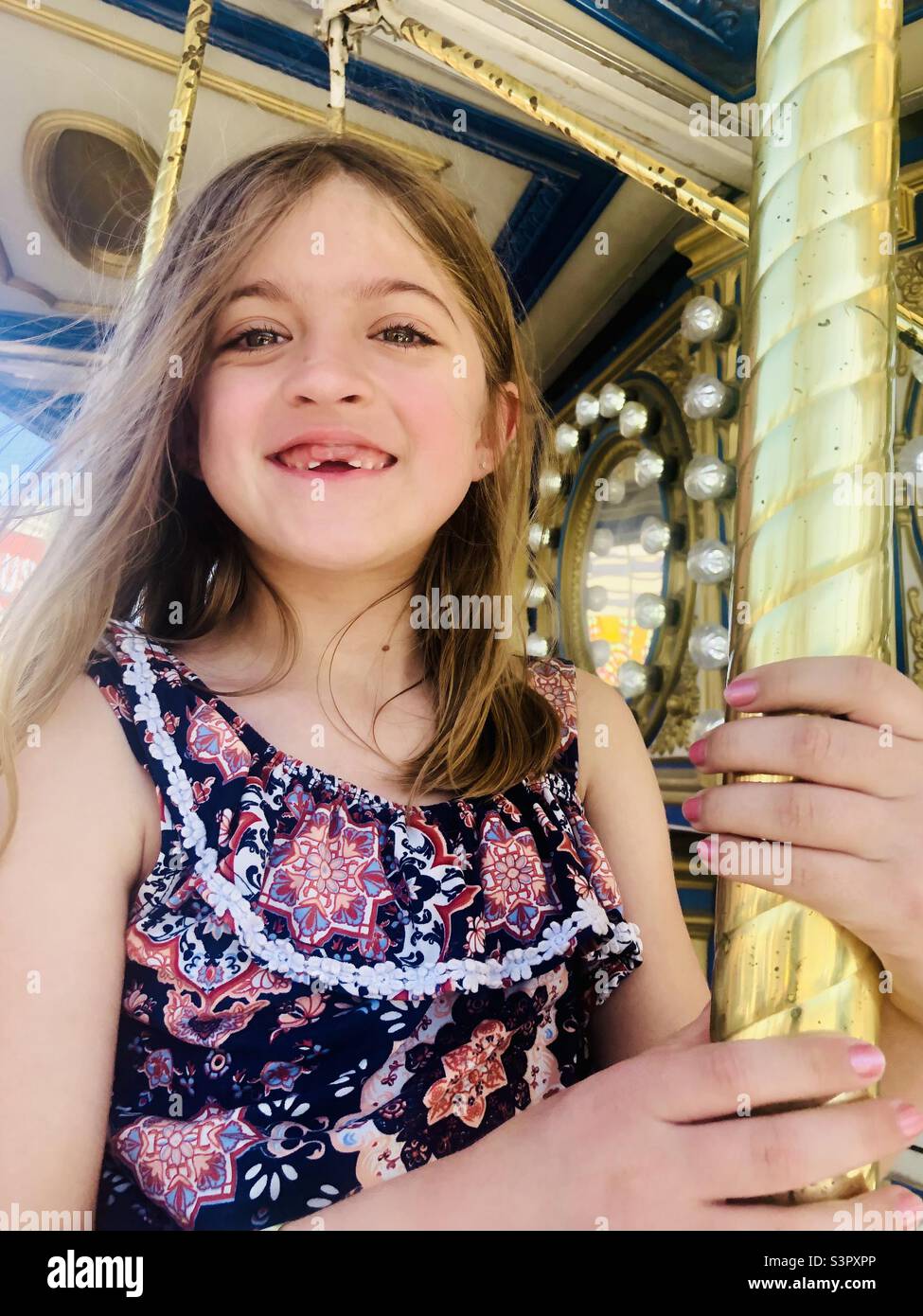 Young girl riding a merry go round Stock Photo