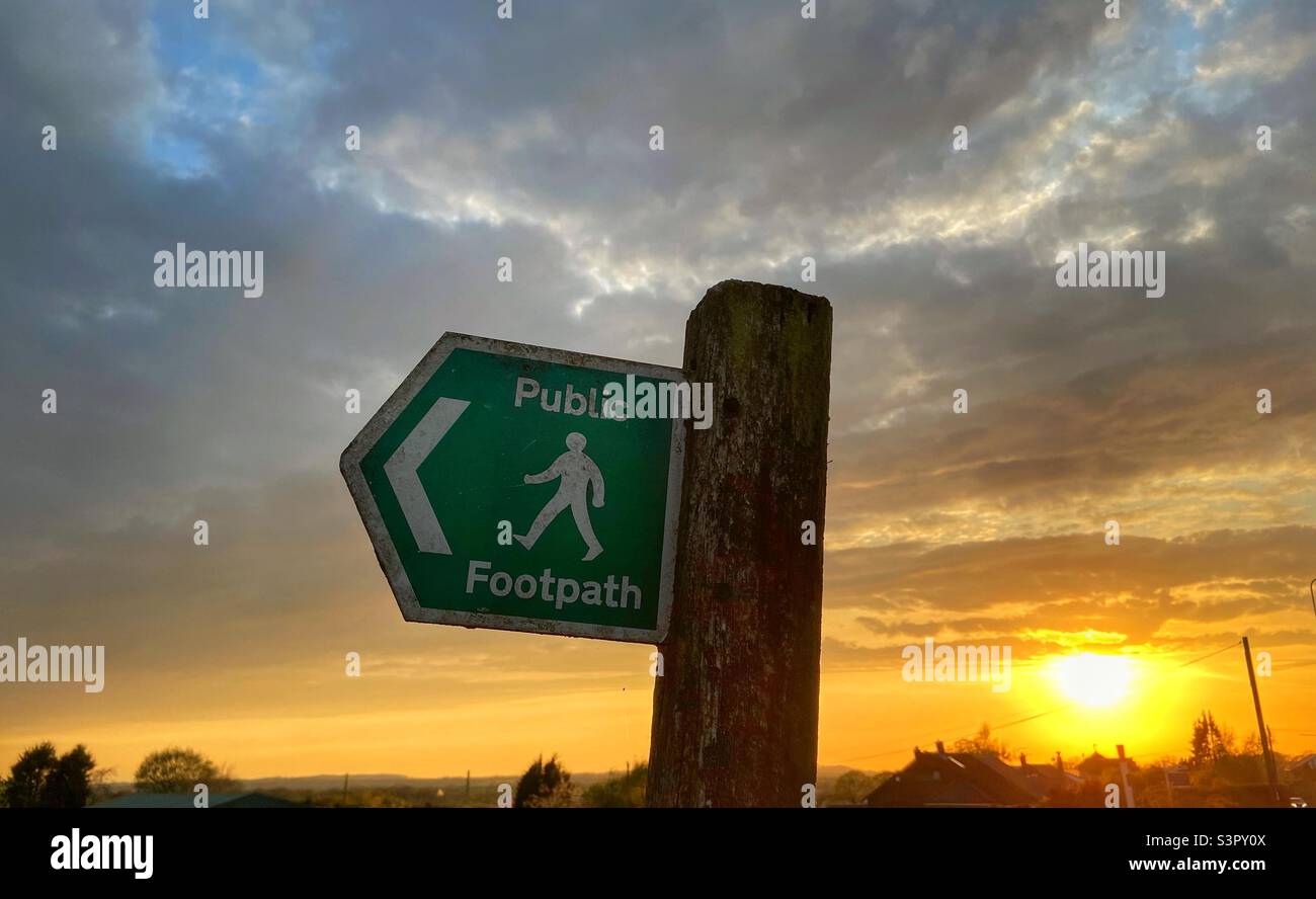 Public footpath sign against sky at sunset Stock Photo