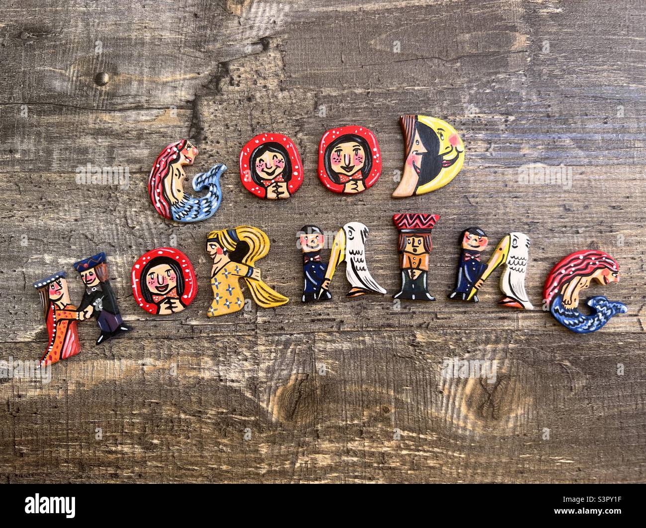 Good morning text composed with funny and creative hand made wooden letters over a wooden board Stock Photo