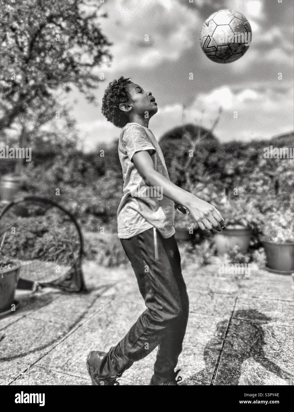 A boy playing football in the garden. Stock Photo