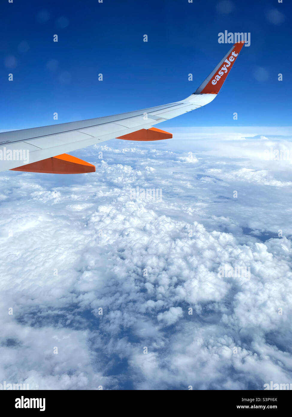 The view from seat 23F of an easyJet Airbus A320 aircraft somewhere over Northern Europe. It’s a privilege to look down at the clouds! Photo ©️ COLIN HOSKINS. - Smartphone Captured Stock Image