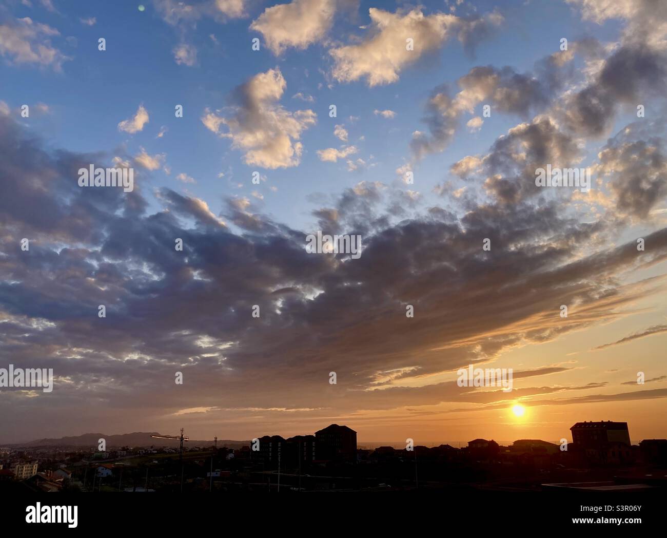 Cloudscape sunset with silhouetted buildings on the coast Santander Cantabria Spain - Smartphone Captured Stock Image