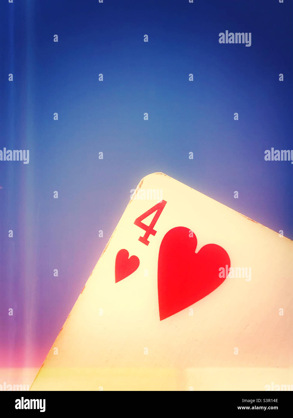 A four of hearts playing card against a blue sky - Smartphone Captured Stock Image