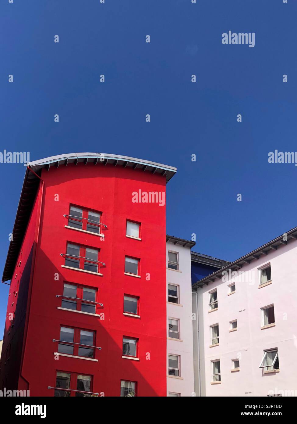 Red building against a blue sky - Smartphone Captured Stock Image