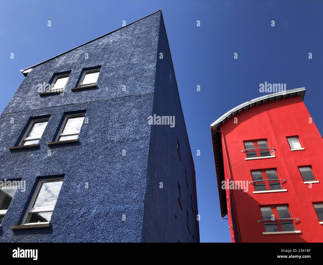 Red and blue building against a blue sky - Smartphone Captured Stock Image