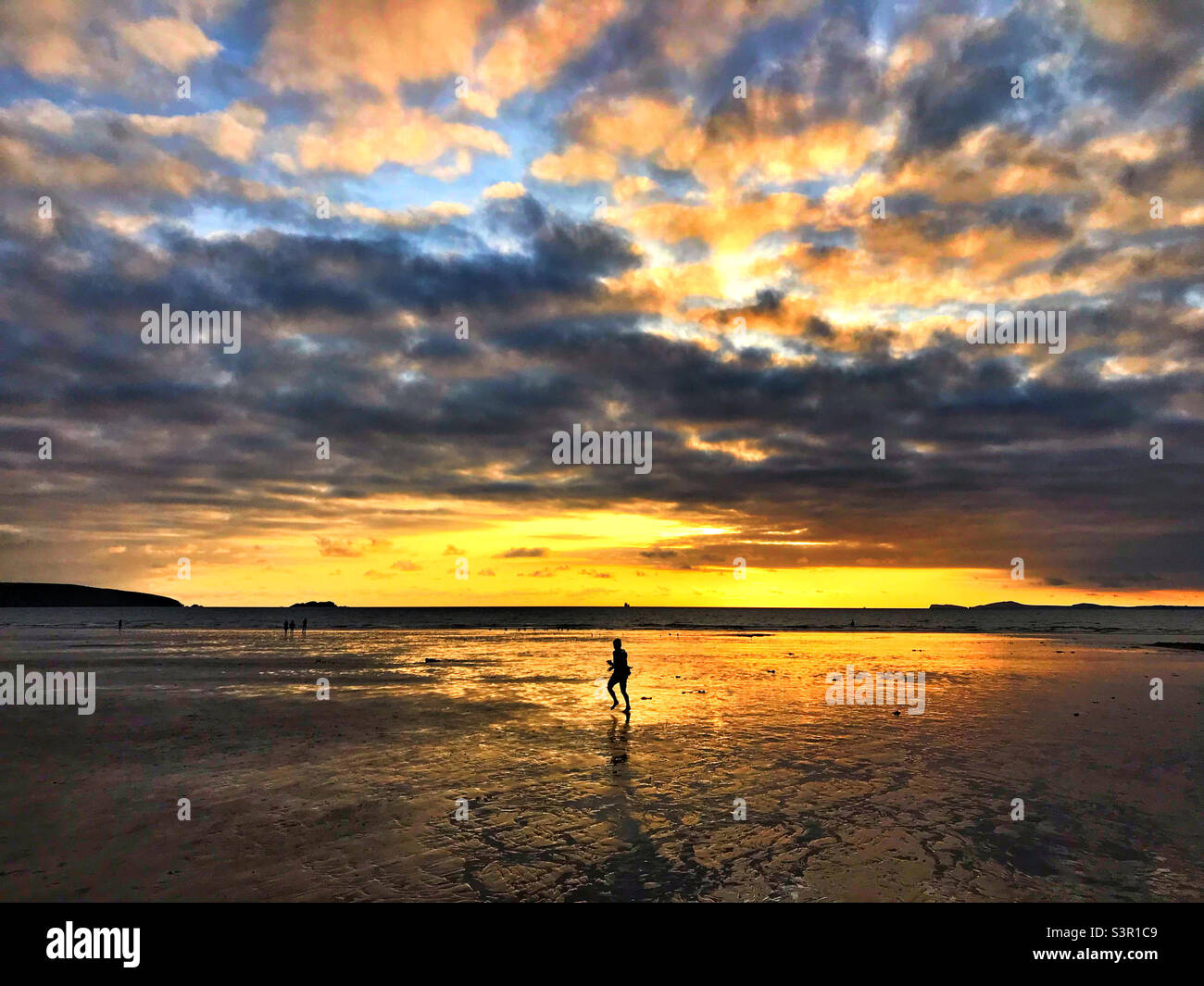 A single figure running on a beach at sunset Stock Photo