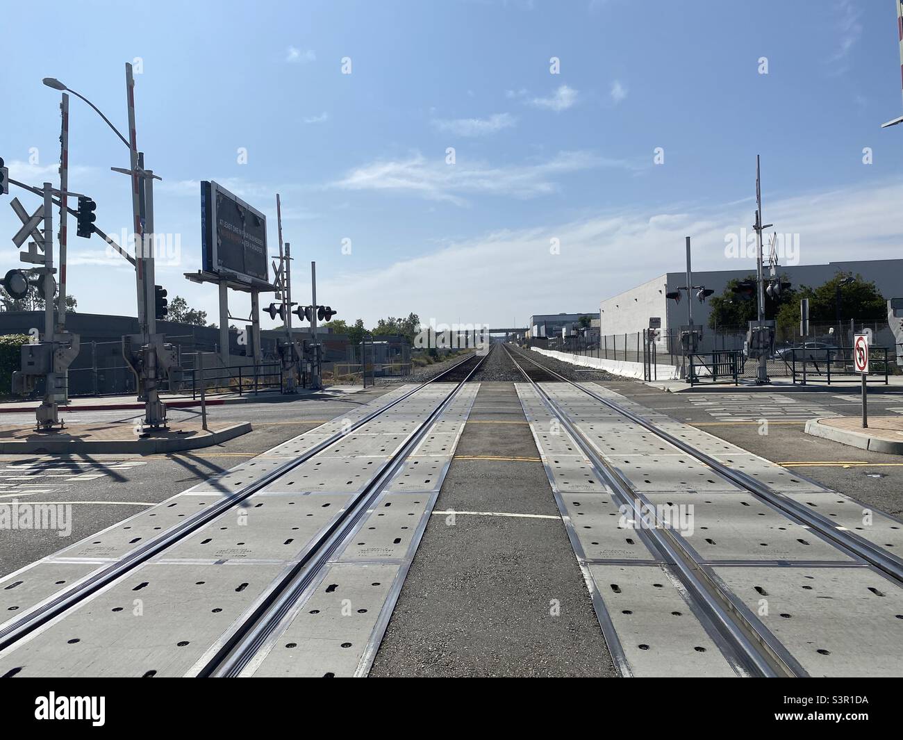 LOS ANGELES, CA, MAY 2021: view of railway tracks heading into the distance, at a road crossing in Glendale - Smartphone Captured Stock Image