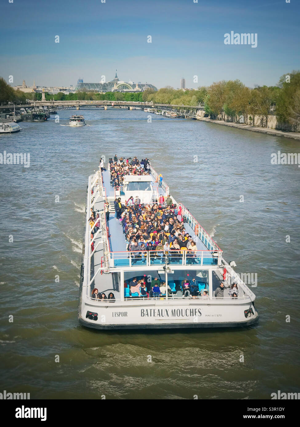 A tourist boat cruising up the River Seine in Paris Stock Photo