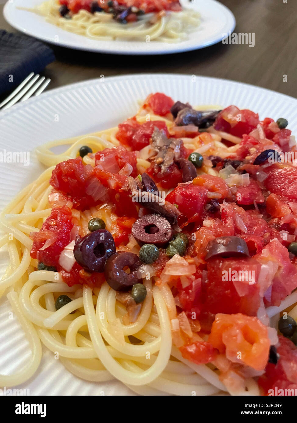 Close up of a Italian meal of puttanesca sauce over spaghetti, 2022, United States - Smartphone Captured Stock Image
