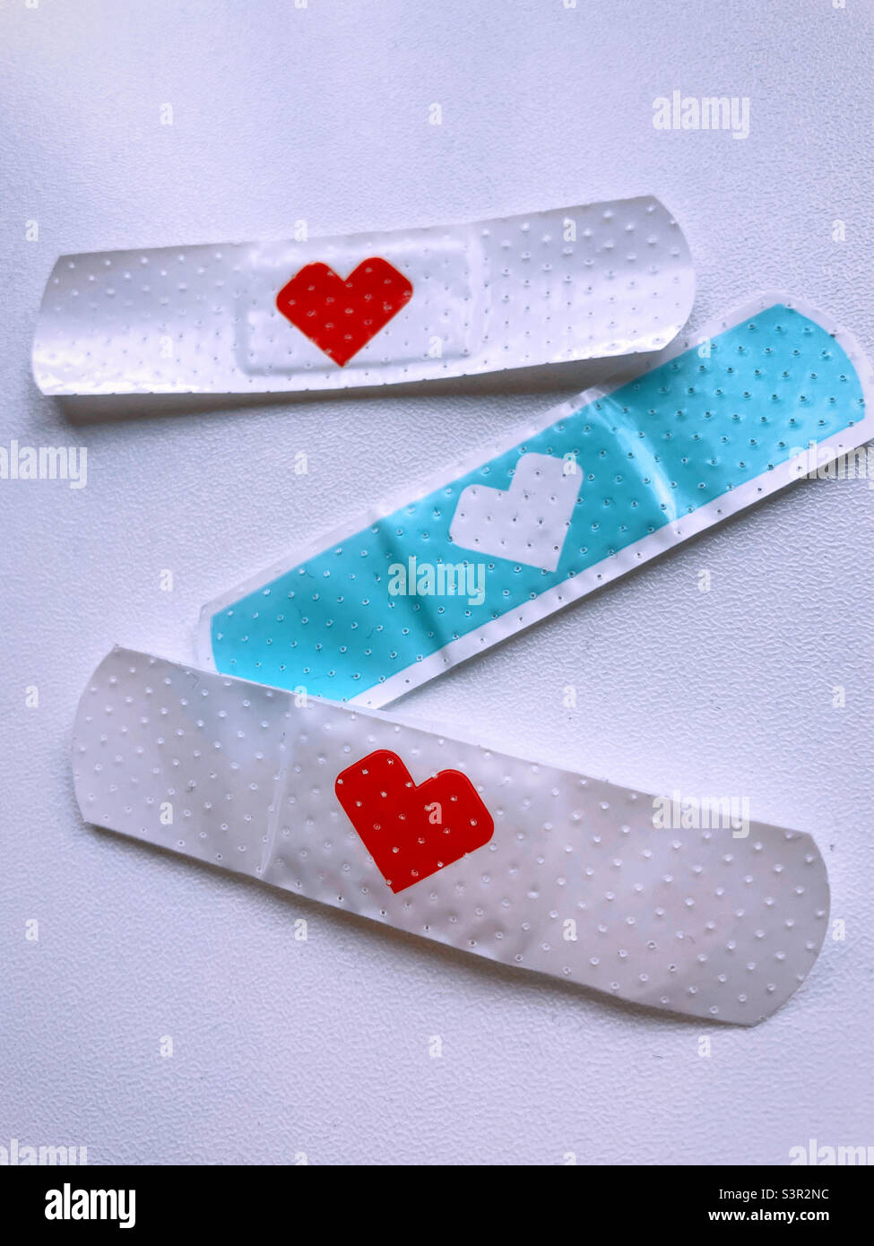 Close up of three Band-Aids with a red heart on each, 2022, United States - Smartphone Captured Stock Image
