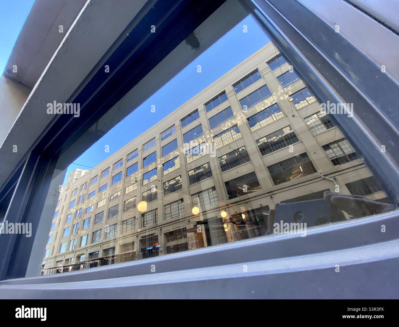 LOS ANGELES, CA, JUN 2021: building reflected in another building at The Row, arts and retail district, converted from industrial units in Downtown Fashion District Stock Photo