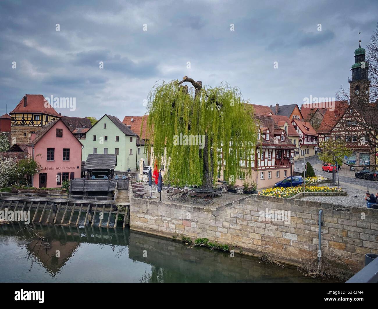 Old timbered houses, big willow tree and water dam over river Pegnitz in Lauf an der Pegnitz near Nuremberg, Germany. Stock Photo
