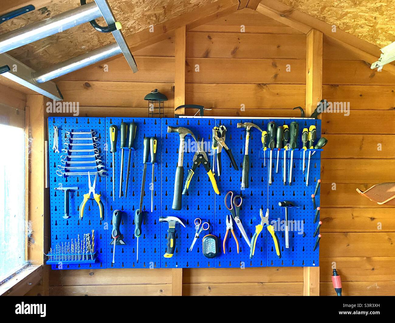 Rack for tools on the wall of a garden shed Stock Photo