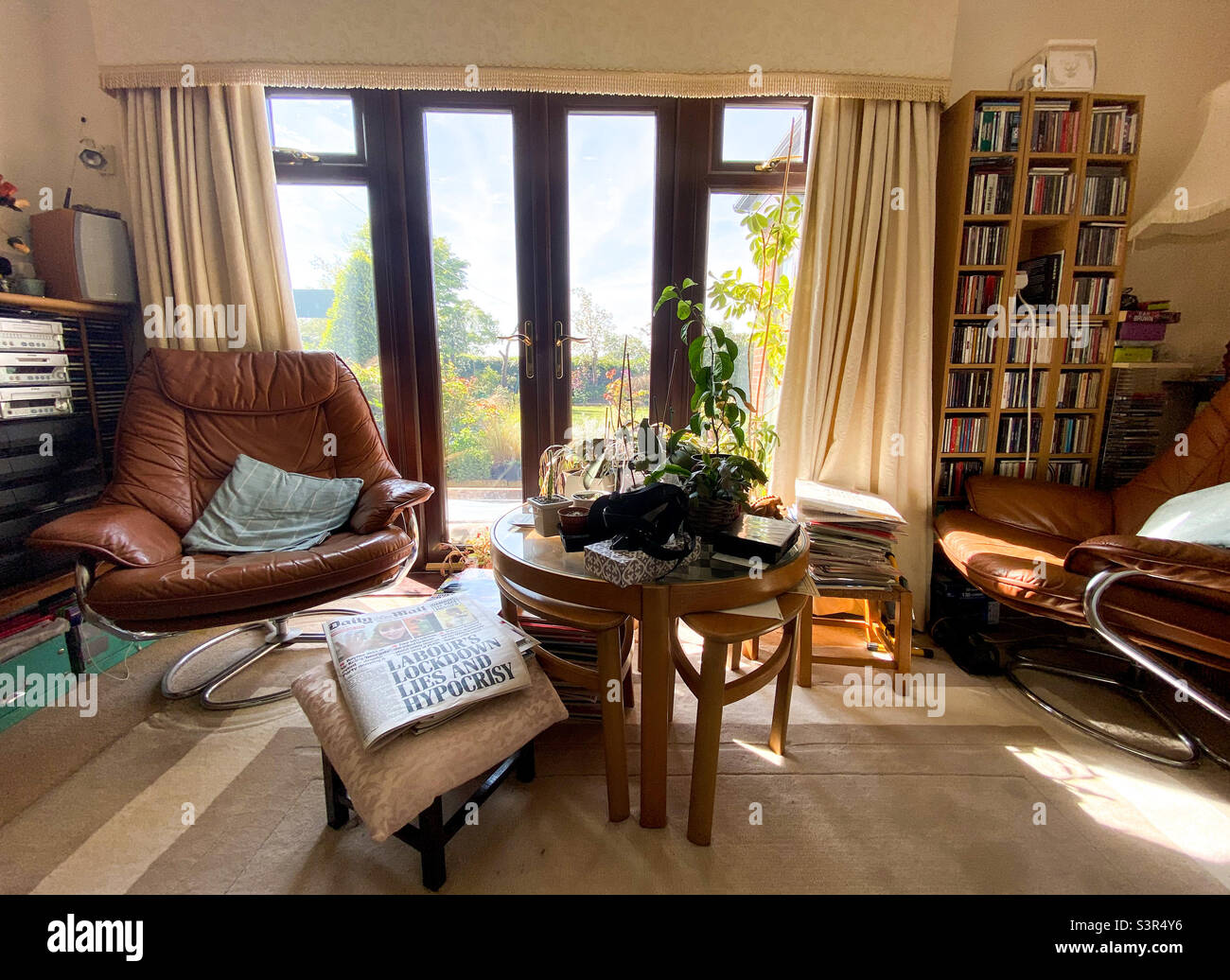 Living room with comfy chairs, centre table and French windows. - Smartphone Captured Stock Image