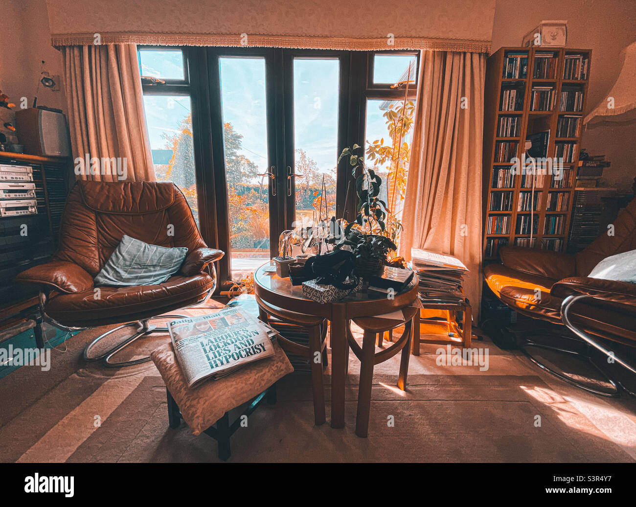 Lounge with comfy chairs, centre table and French windows. - Smartphone Captured Stock Image