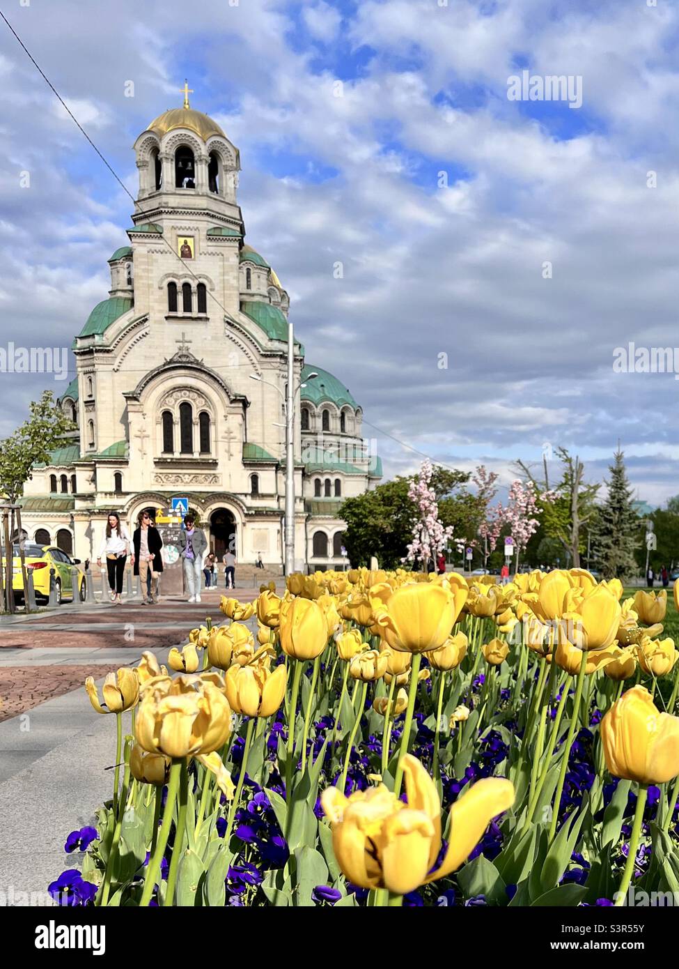 St. Alexander Nevsky orthodox cathedral view and yellow tulips on a sunny Spring day in Sofia Bulgaria, Balkans, Eastern Europe, EU - Smartphone Captured Stock Image