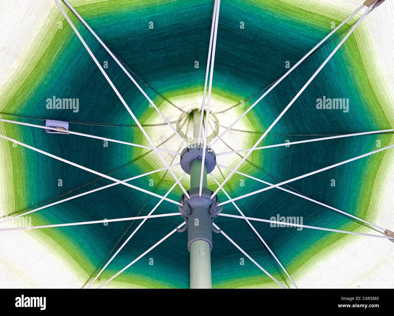 Underside of a green and white umbrella on the terrace of a restaurant in Madrid Spain - Smartphone Captured Stock Image