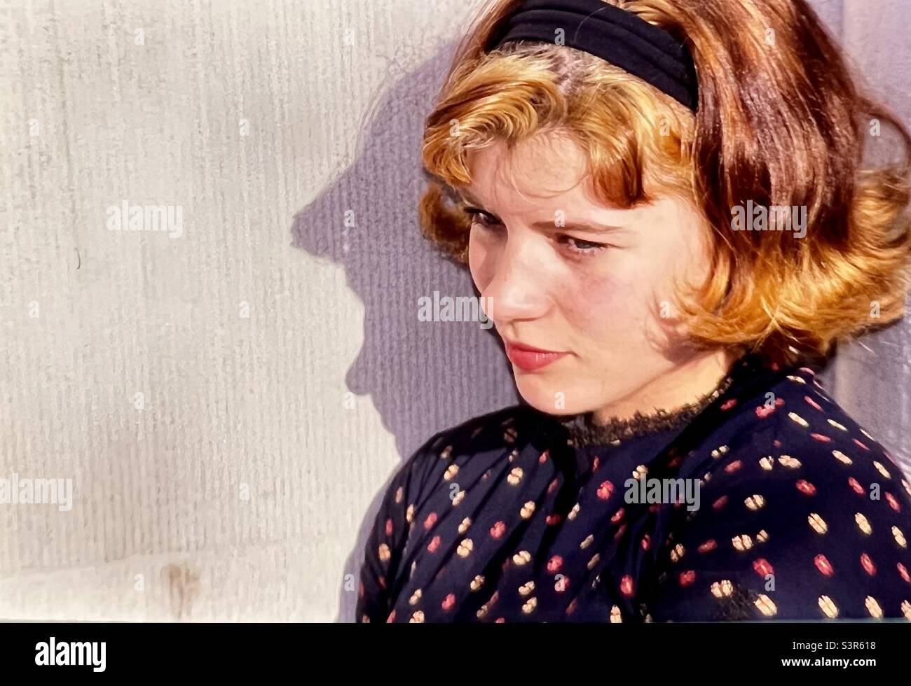 Young woman portrait thinking against wall with shadow Stock Photo