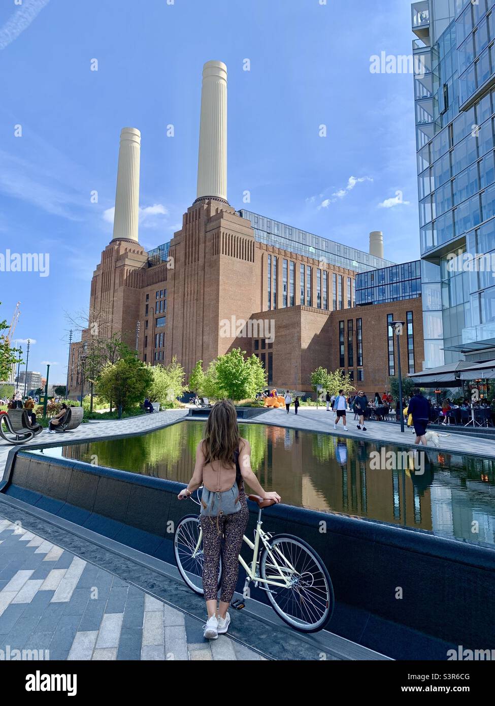 Woman with bike looking at Battersea Power station - Smartphone Captured Stock Image