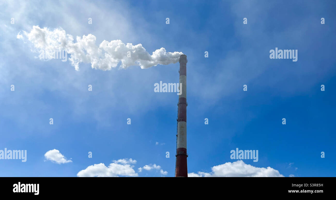 Chimney on a cloudy sky background with copyspace. Emissions of industrial waste into the atmosphere. Environmental pollution - Smartphone Captured Stock Image