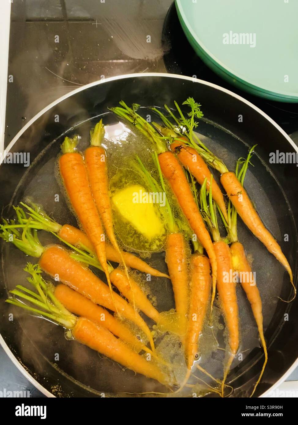 Simmered orange carrots in a pan of stock & butter - Smartphone Captured Stock Image