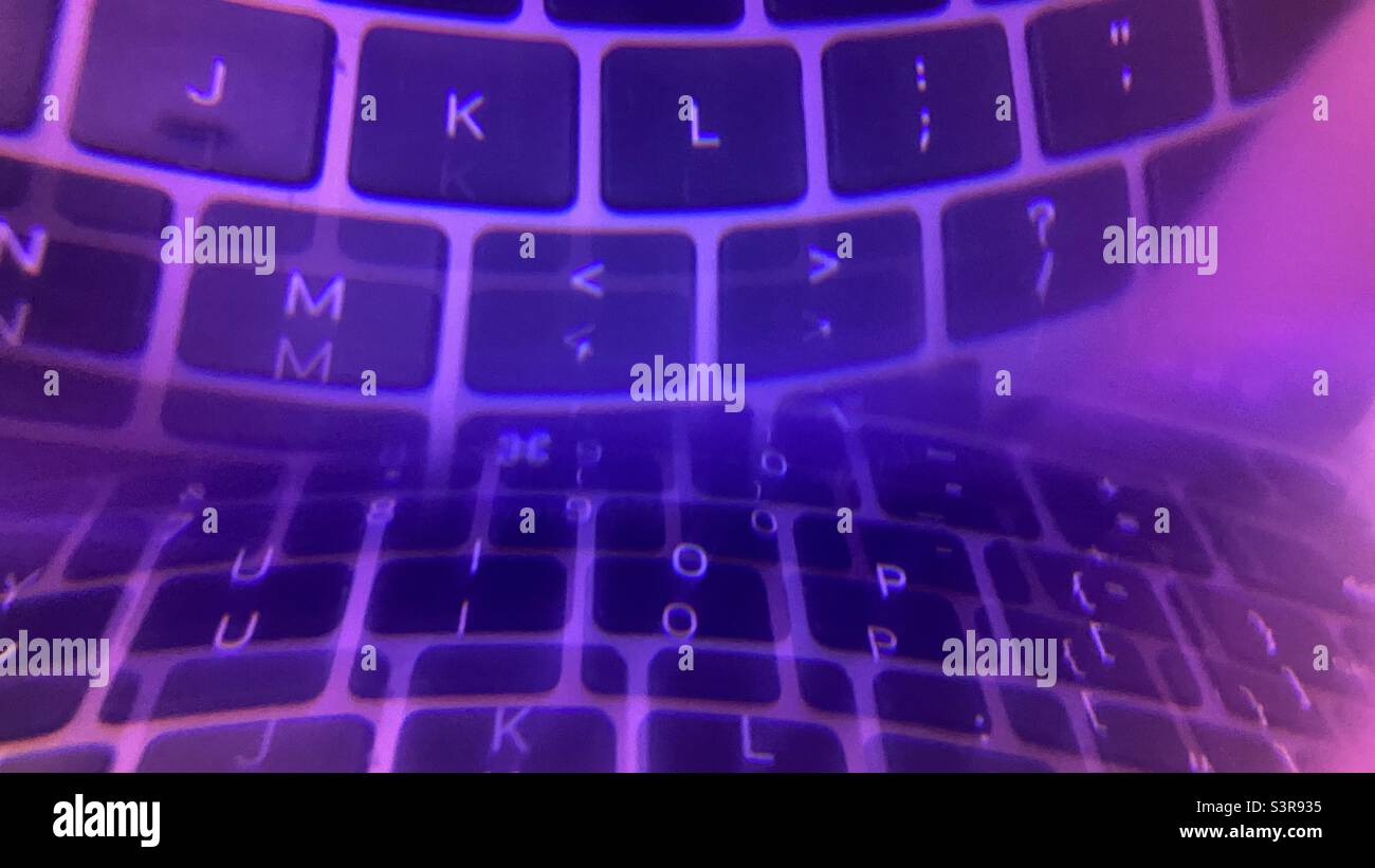 Colorful abstract pattern created with prism in front of camera lens. Letters on a computer keyboard reflected and refracted with purple hue - Smartphone Captured Stock Image