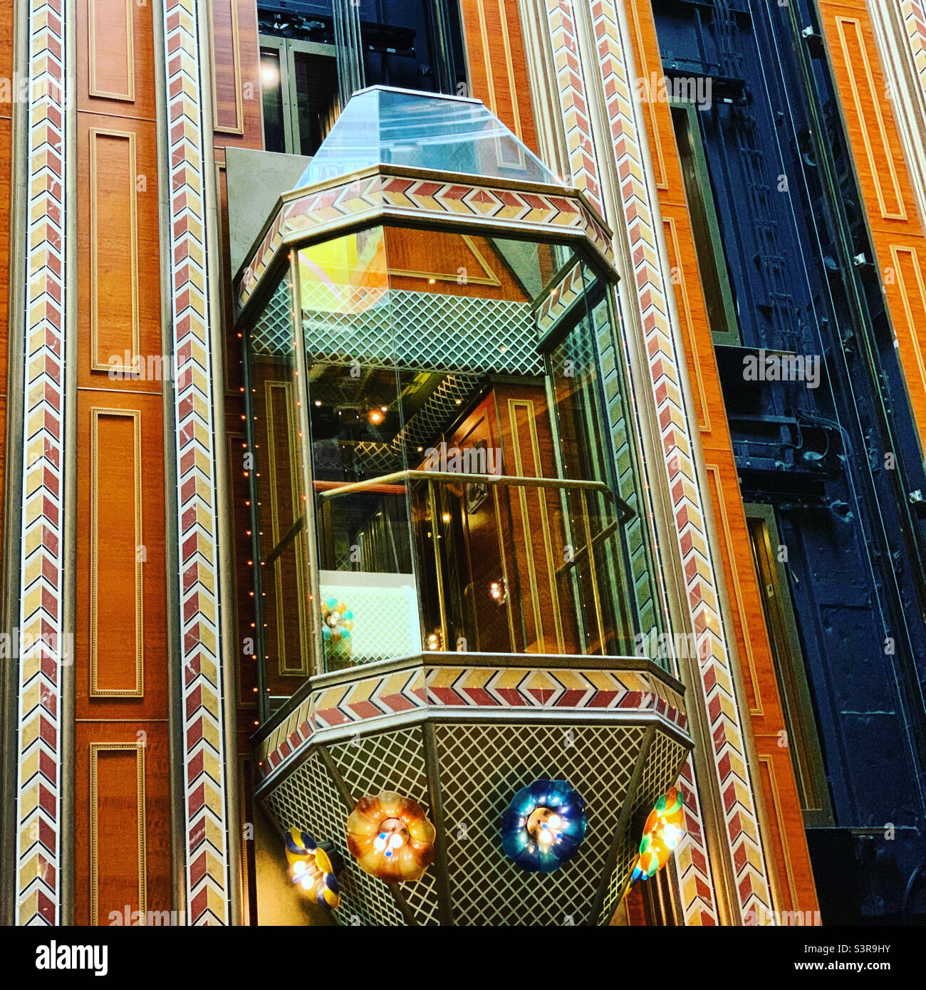 A glass elevator in the atrium of the Carnival Conquest cruise ship, in port at Port Miami, Miami, Florida, United States, prior to a cruise to the Bahamas - Smartphone Captured Stock Image