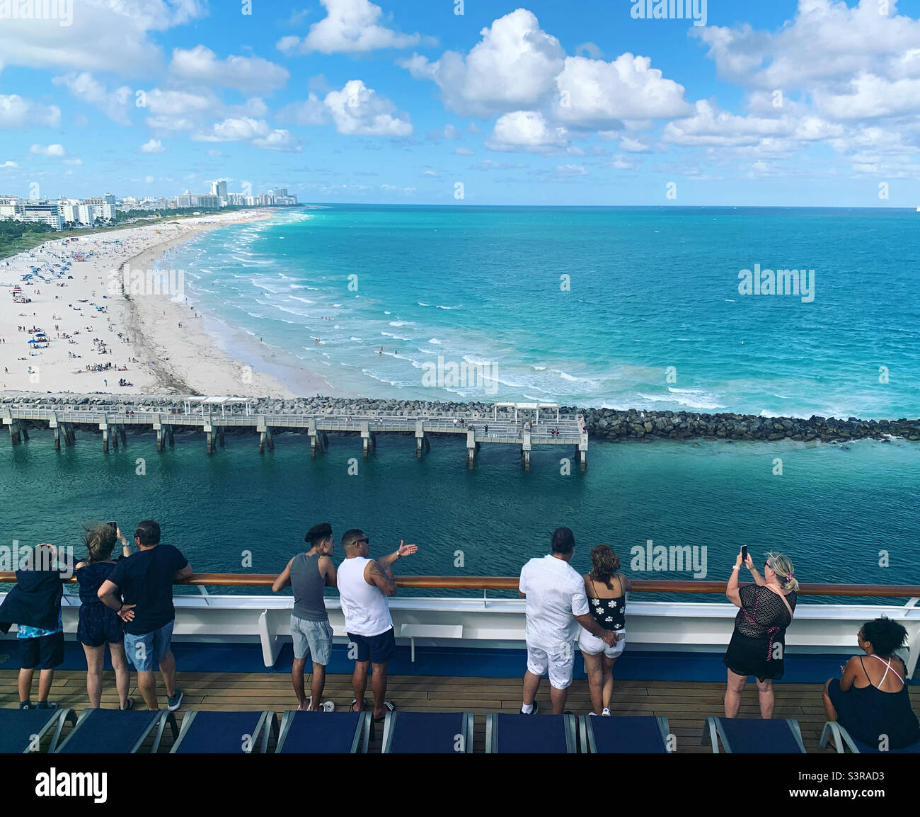 March, 2022, people take in views of South Beach, Miami Beach, from the deck of a cruise ship leaving the Port of Miami - Smartphone Captured Stock Image