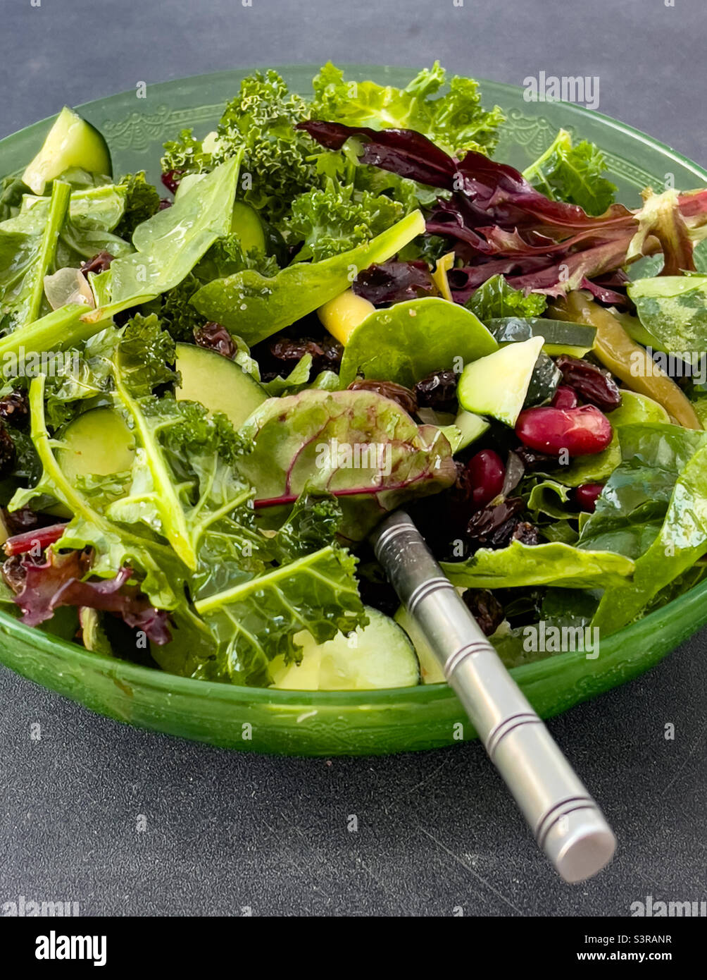 https://c8.alamy.com/comp/S3RANR/closeup-side-view-mixed-green-salad-in-green-glass-bowl-with-inserted-fork-S3RANR.jpg