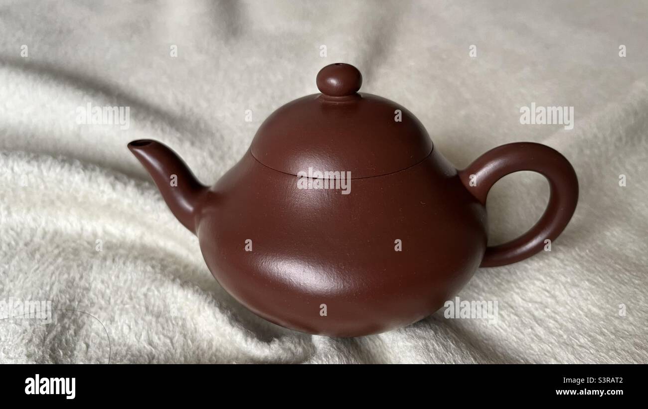 A handcrafted Yixing Zisha teapot with a smooth, rounded design, highlighting the traditional craftsmanship and simplicity of Chinese tea culture. - Smartphone Captured Stock Image