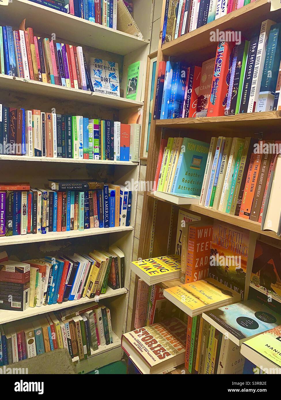 Two Walls of Brightly Colored Books on Wooden Shelves that Meet in the Center - Smartphone Captured Stock Image