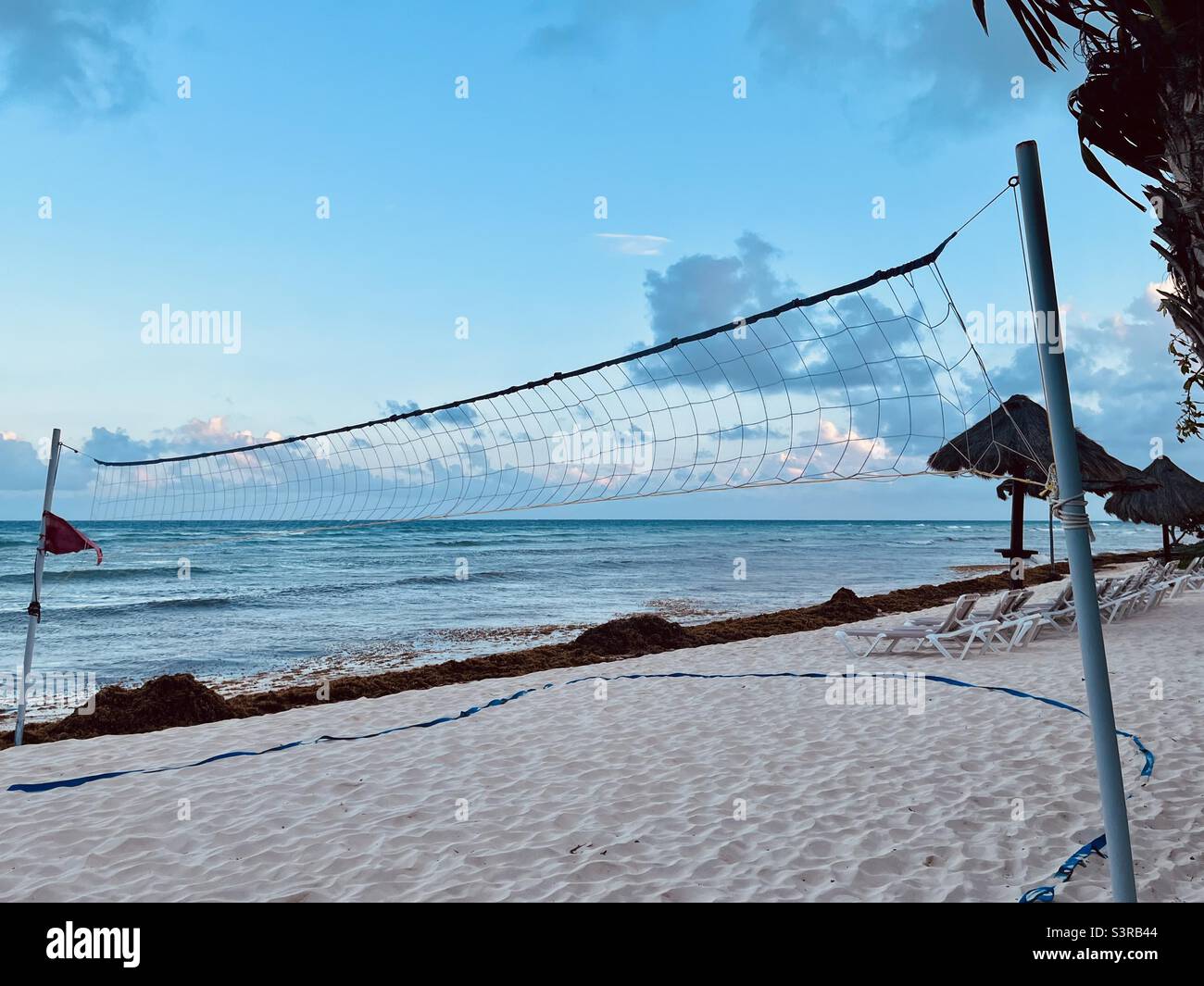 Dusk on the beach with red flag and volleyball net - Smartphone Captured Stock Image