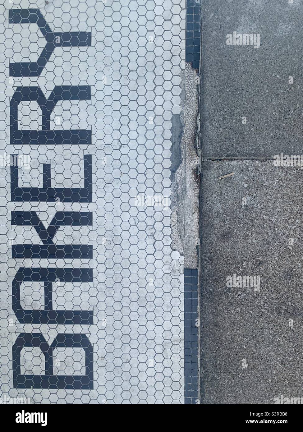 Black and White Tile Floor Outside of Bakery says BAKERY - Smartphone Captured Stock Image