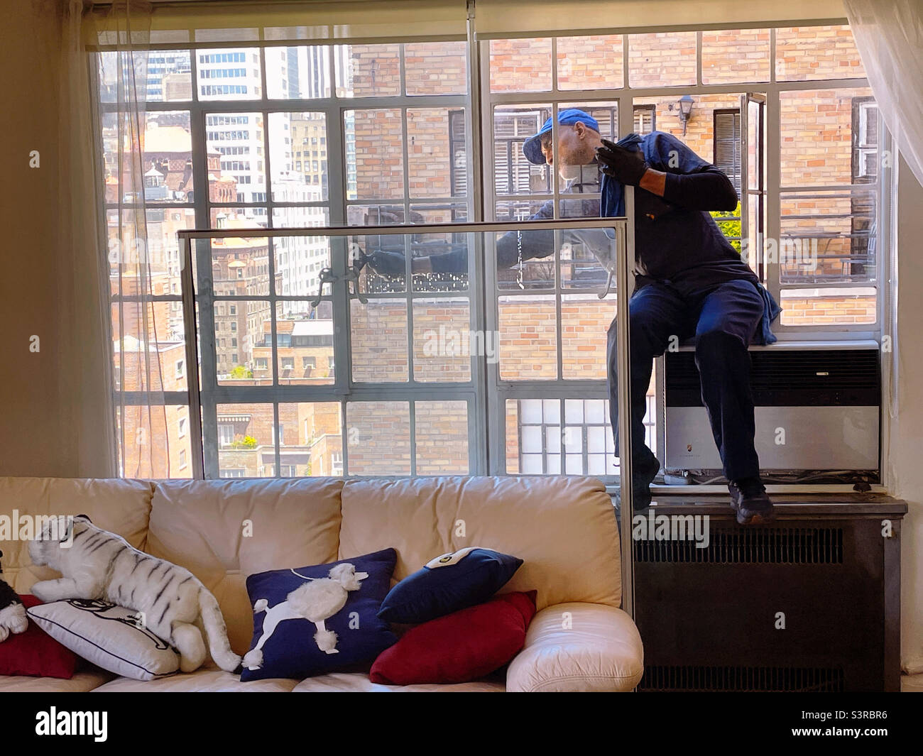 Professional window washer cleaning casement windows in Midtown Manhattan, 2022, New York City, United States - Smartphone Captured Stock Image