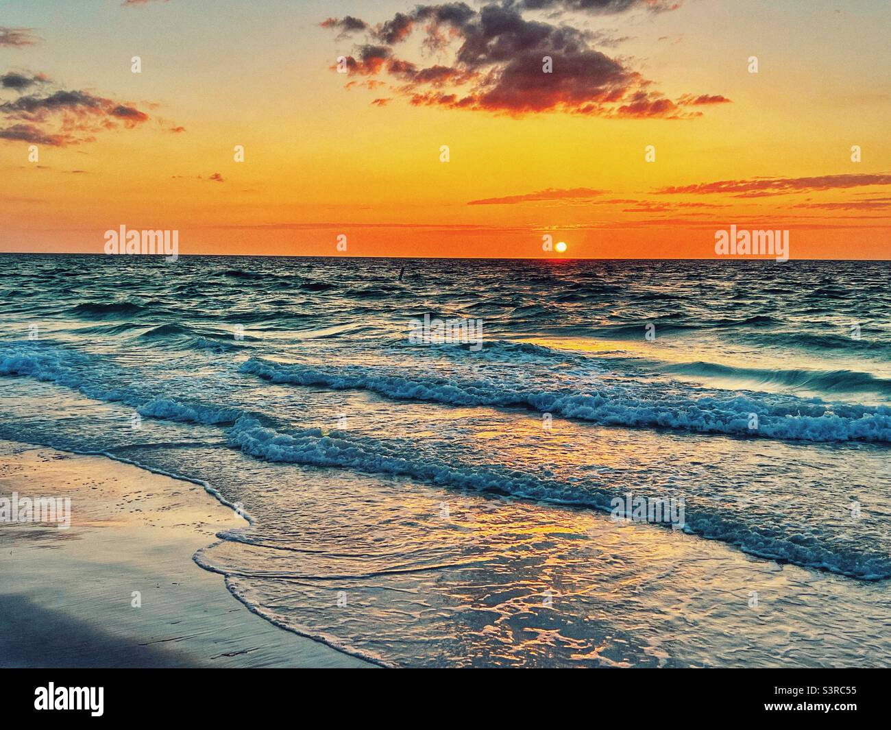 Sunset over the waves at Bean Point Beach on Anna Maria Island in Florida Stock Photo