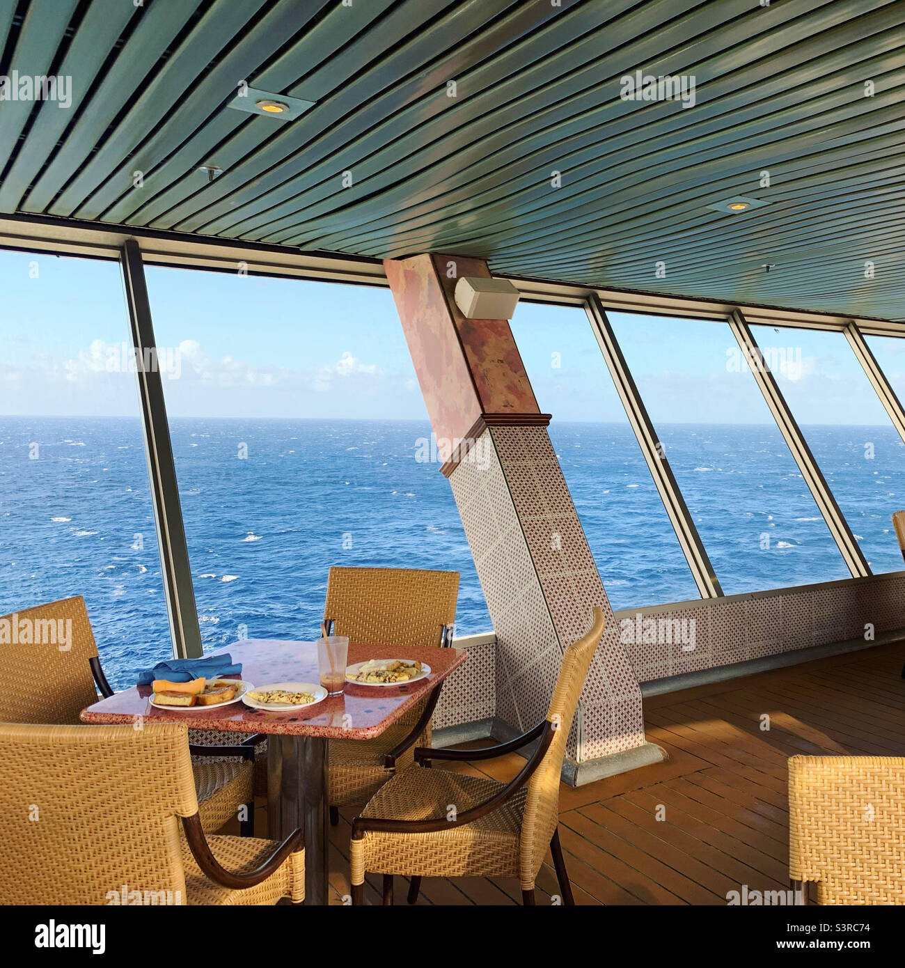 March, 2022, a breakfast table overlooking the ocean on board the Carnival Conquest during a cruise from Miami, Florida to the Bahamas Stock Photo