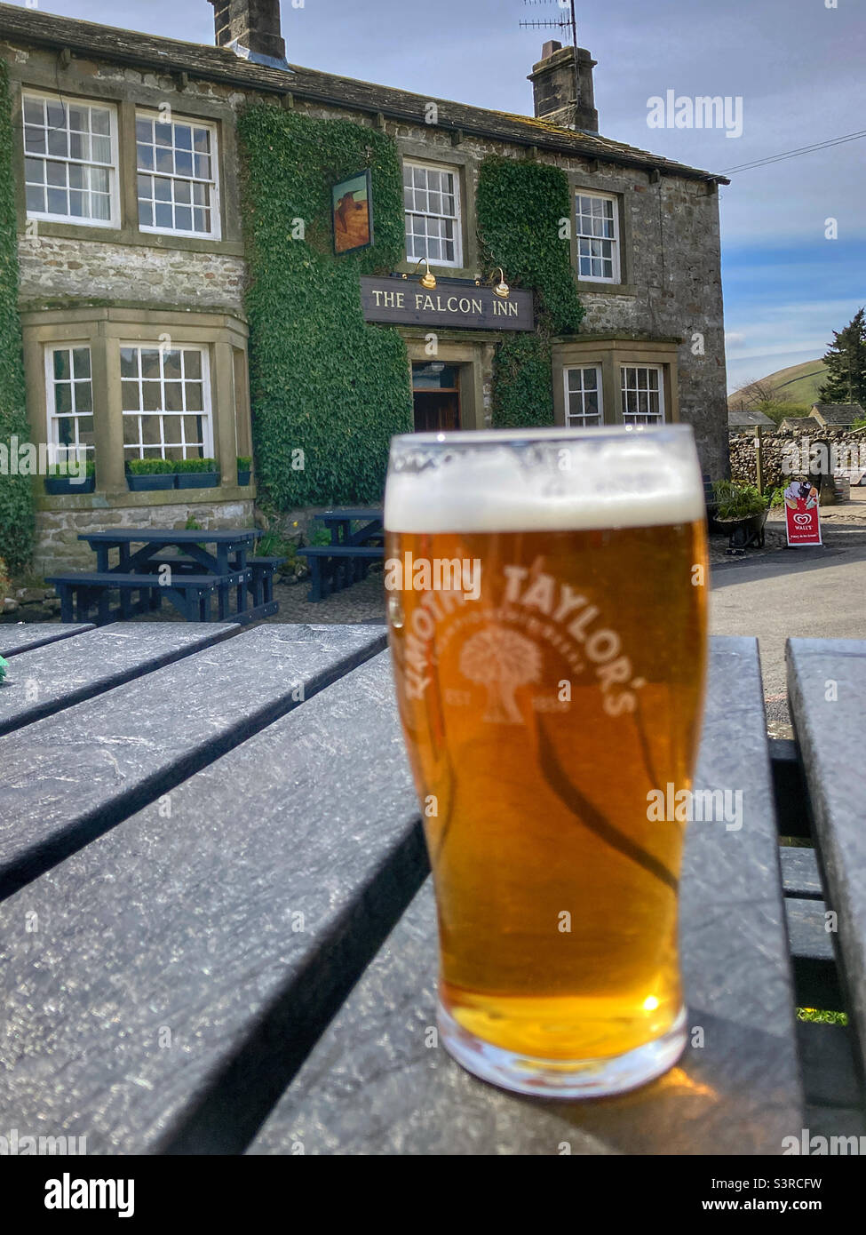 Pint of Timothy Taylor’s outside The Falcon Inn Arncliffe Yorkshire Dales Stock Photo