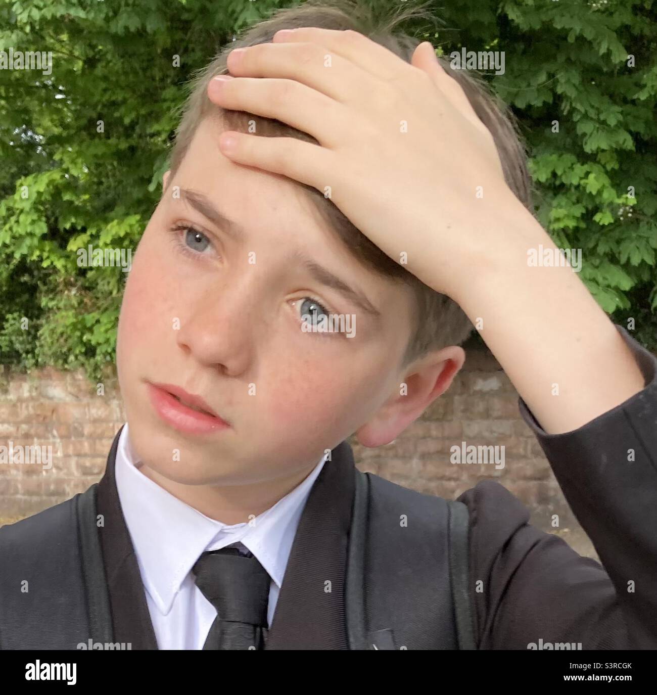 Boy sighing with hand on forehead Stock Photo