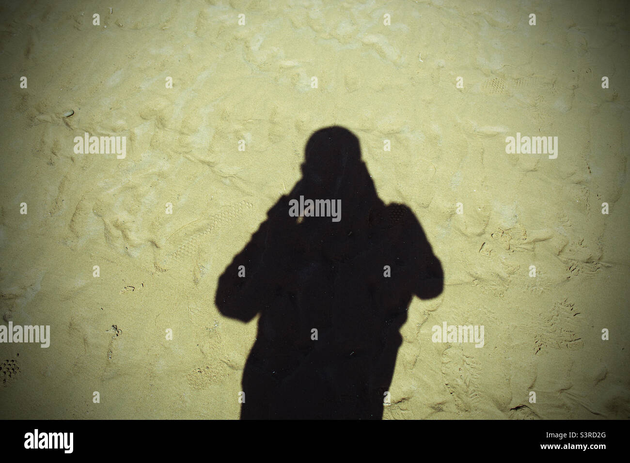 Shadow of a man in the sand at Crosby Beach in Liverpool, Merseyside - Smartphone Captured Stock Image