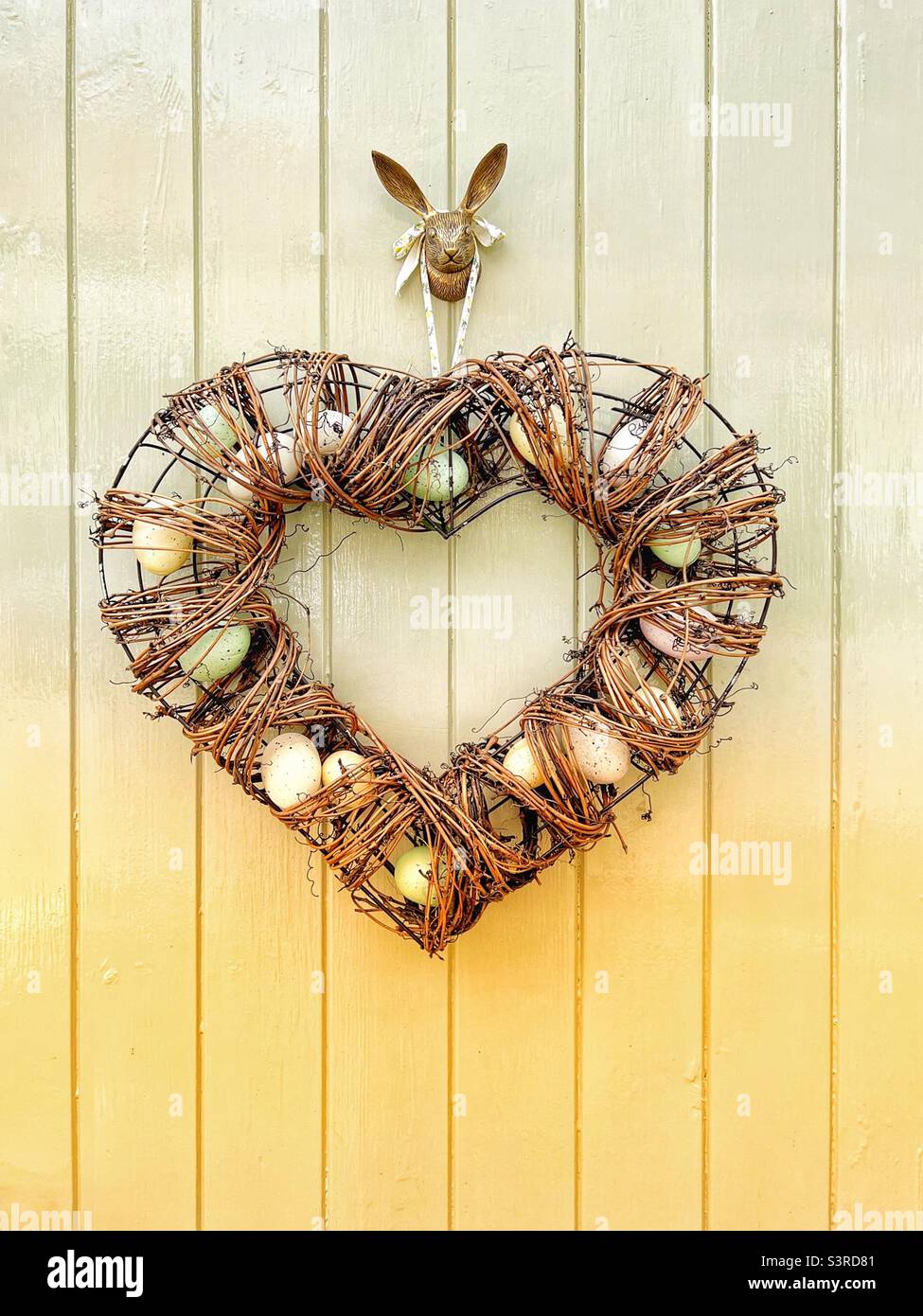 Heart-shaped wreath on a painted door Stock Photo