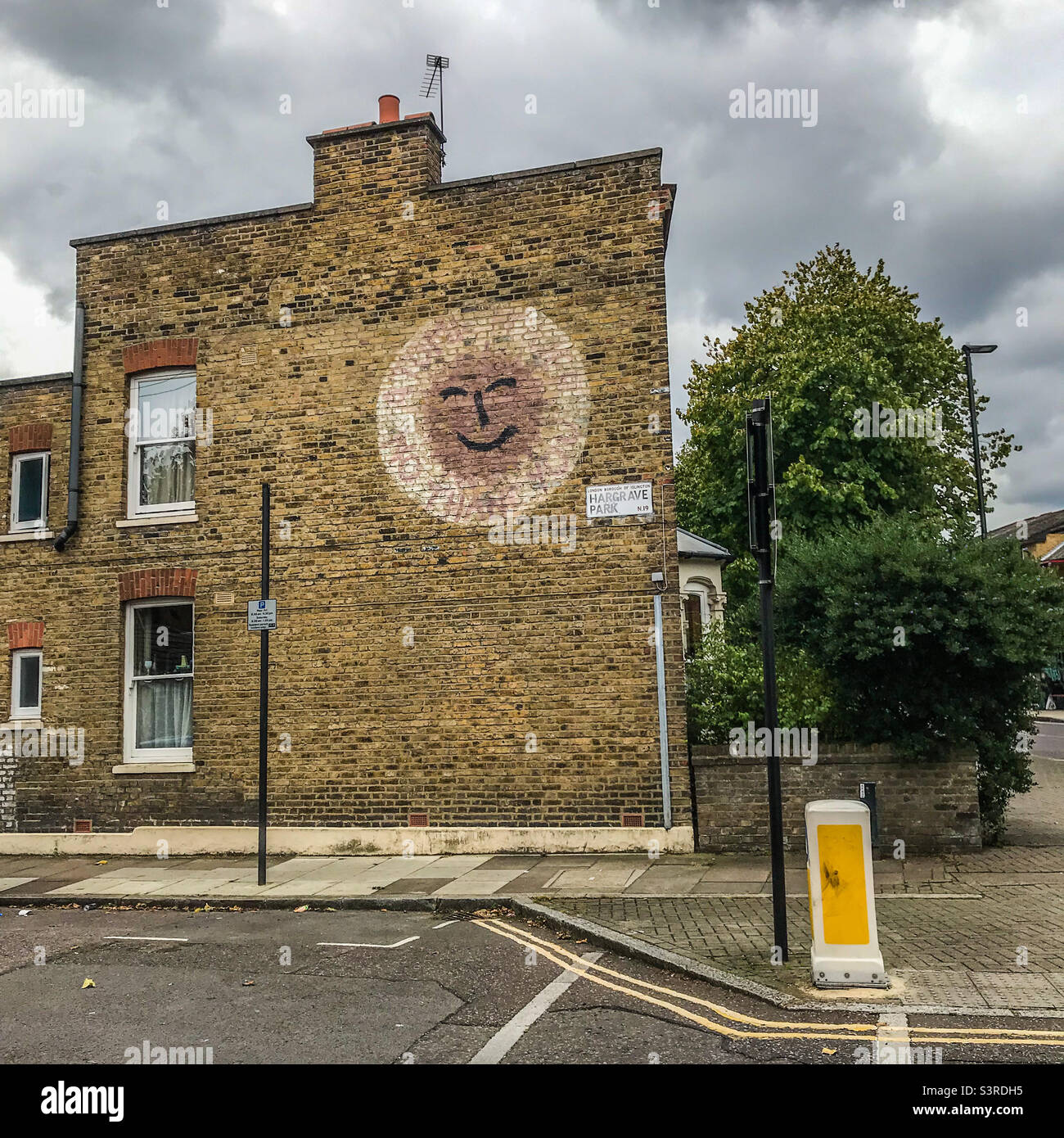 Smiley face on a house wall, Dartmouth Park - Smartphone Captured Stock Image