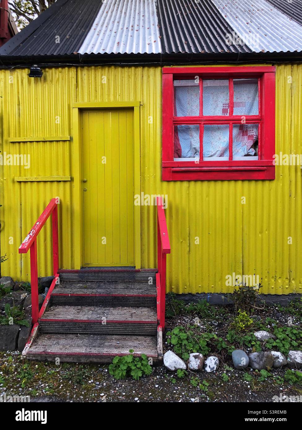 https://c8.alamy.com/comp/S3REMB/red-window-on-yellow-corrugated-out-building-S3REMB.jpg