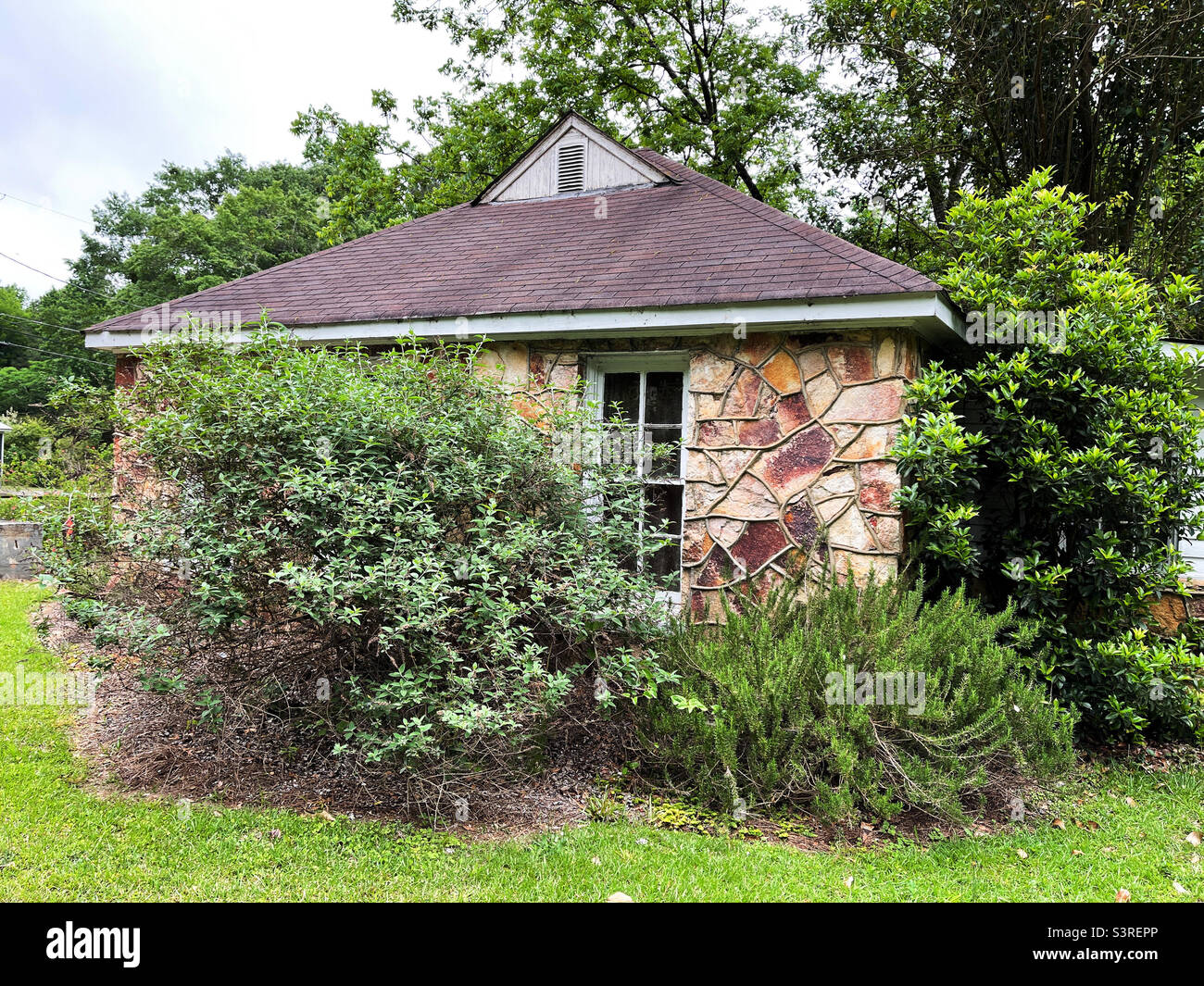Historic masonry built house with grapevine joint architectural style surrounded by native plants. Built in 1935. Stock Photo