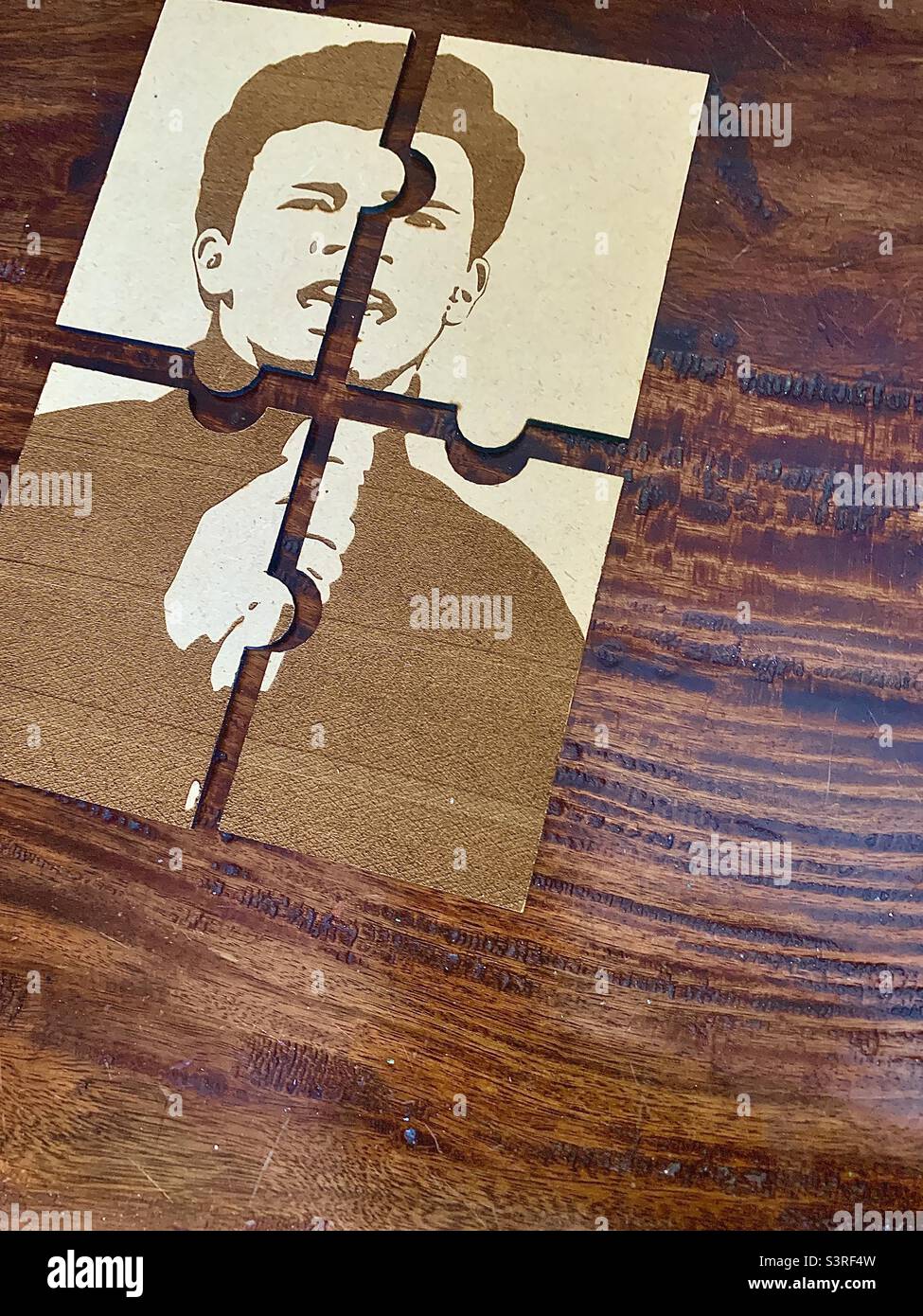 4 piece puzzle of guy on top corner of wooden table with negative space Stock Photo