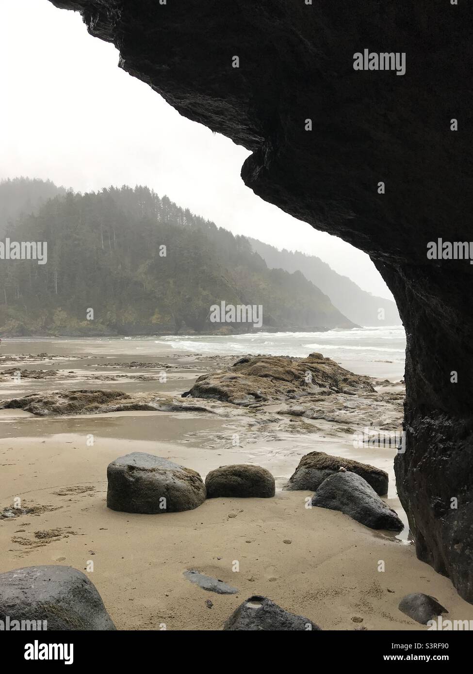 Coastal cave in Oregon. on looking the beach; water and mountains. Stock Photo