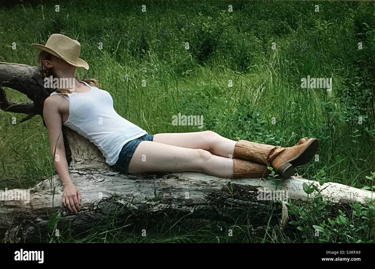 Thistle, weed, summer, shorts, grass, relaxing, resting, lazy day, park, hat, sleeping, boots Stock Photo