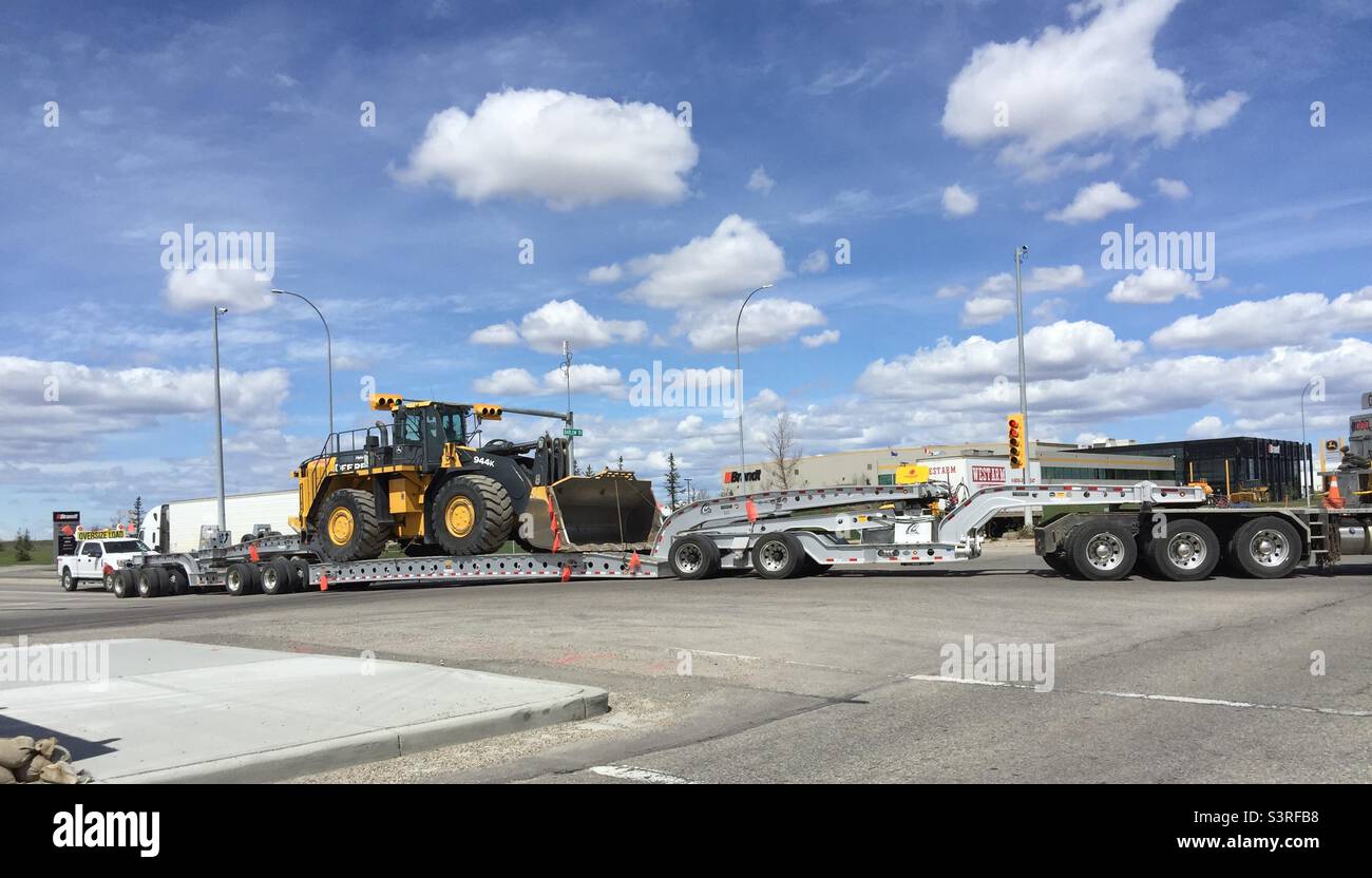 Big truck, heavy machine. front end loader, many wheels, blue sky, fluffy clouds, - Smartphone Captured Stock Image