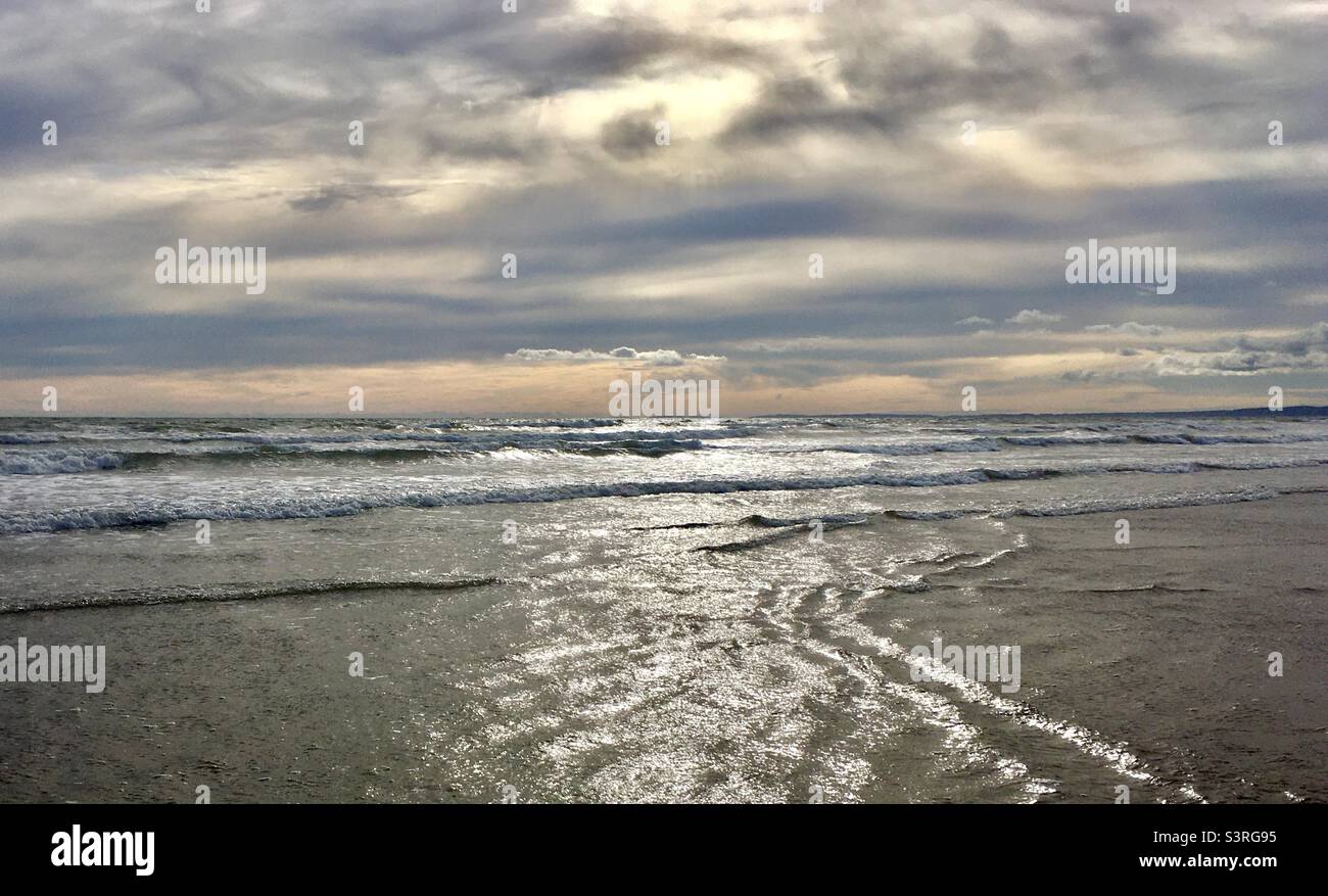 Sun, clouds, beach, sea. (Burry Port beach) Stock Photo