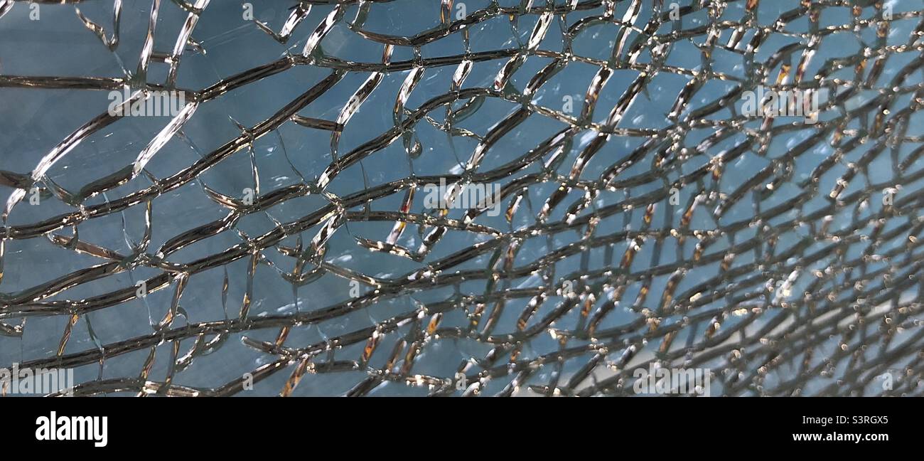 Broken glass abstract against a light blue background Stock Photo