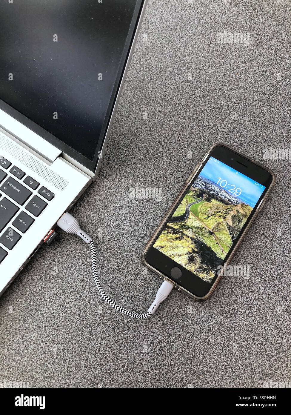 Apple iPhone SE Mobile smart phone charging via laptop USB port Stock Photo